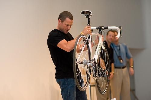 Lance Armstrong checks his bew bike, the PM is in the shadows-jpg